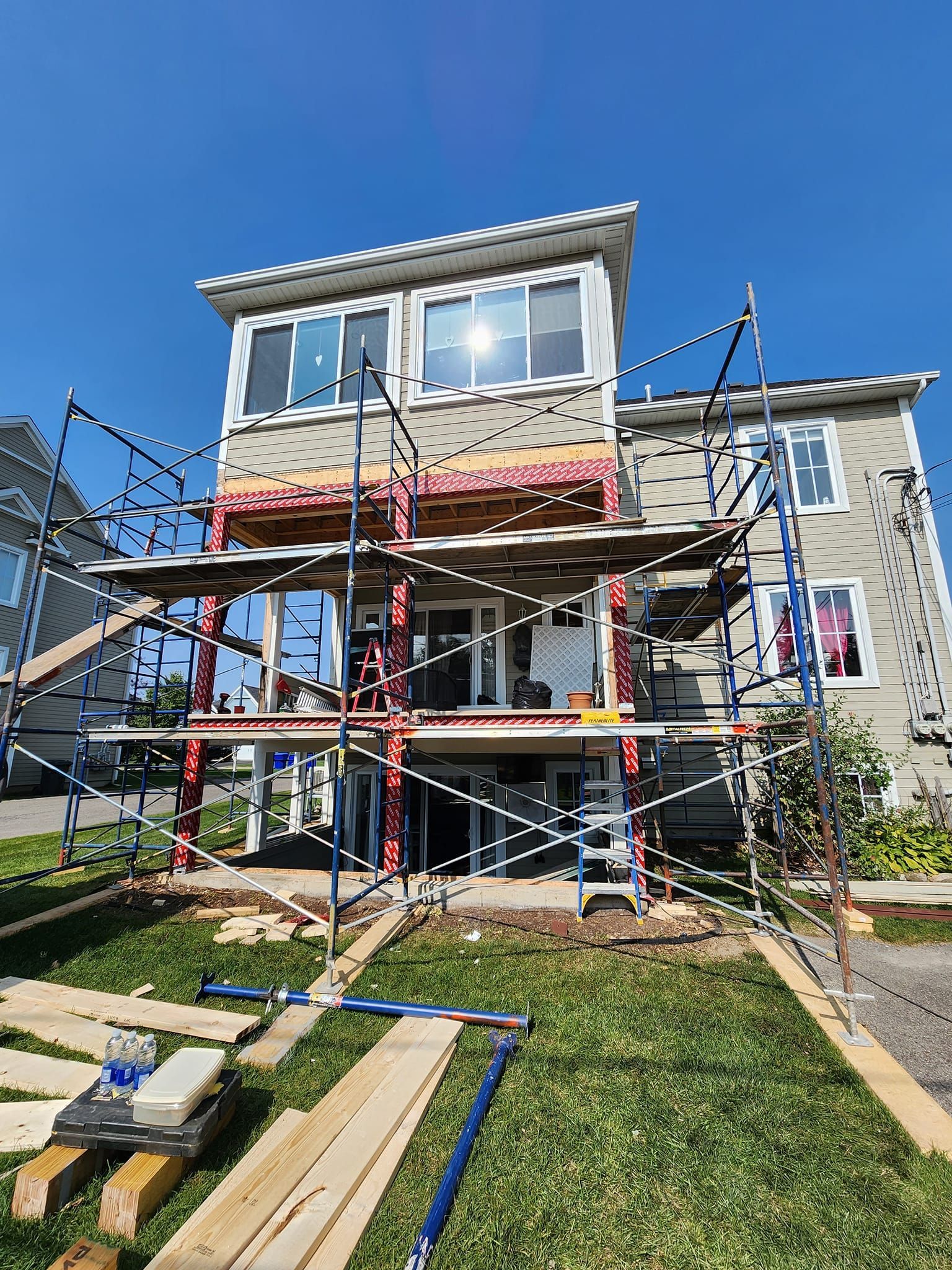 Une maison est en cours de rénovation avec des échafaudages autour.