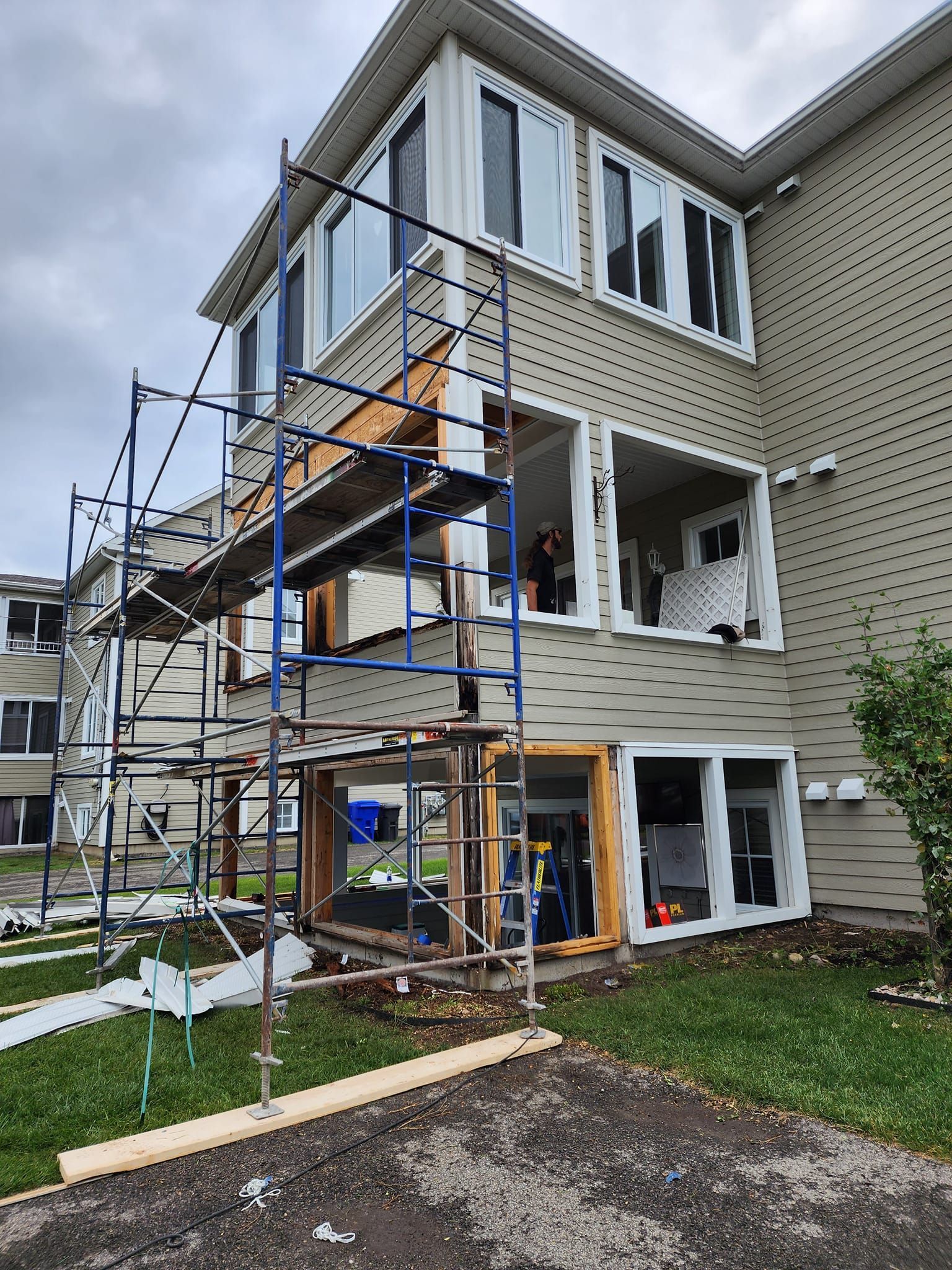 Une maison est en cours de rénovation avec des échafaudages autour.