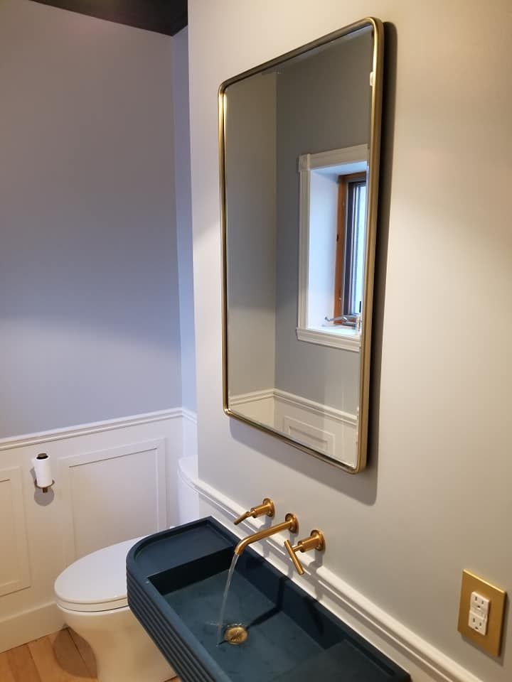 Une salle de bain avec lavabo, WC et miroir.