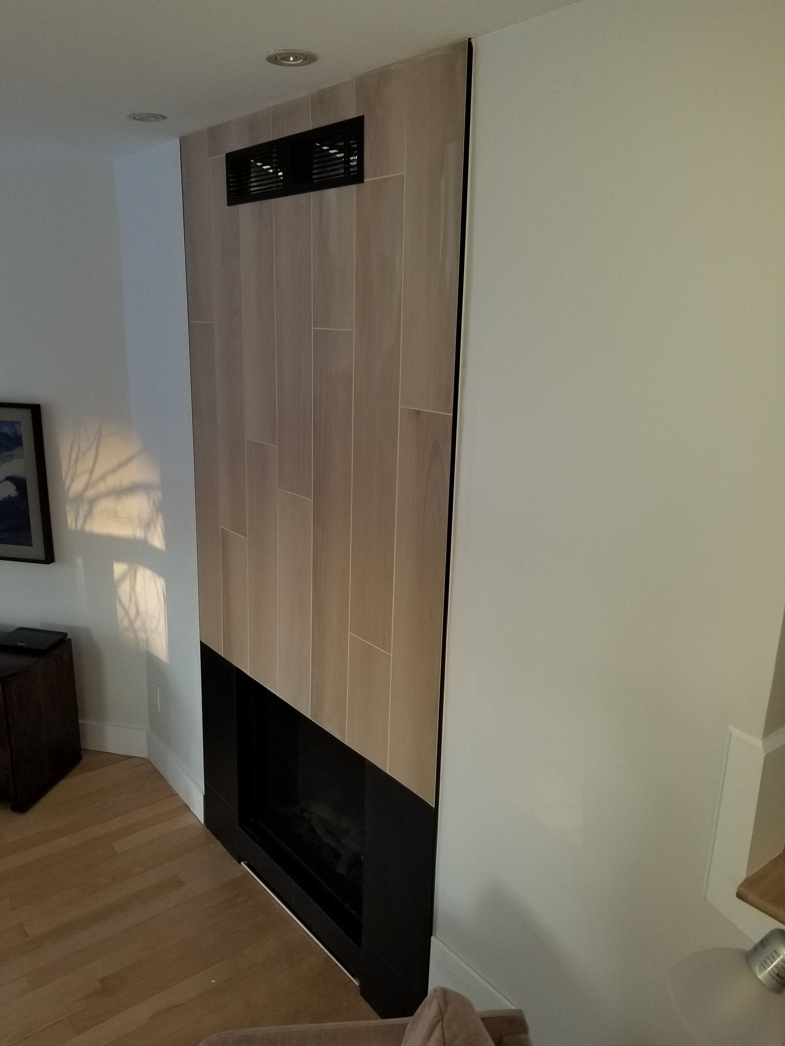 Un salon avec une cheminée et un tableau au mur.