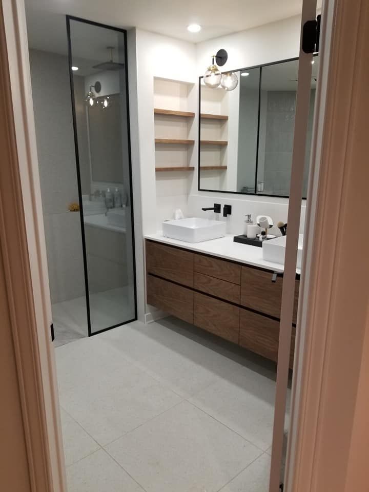 Une salle de bain avec deux vasques et une douche à l'italienne.