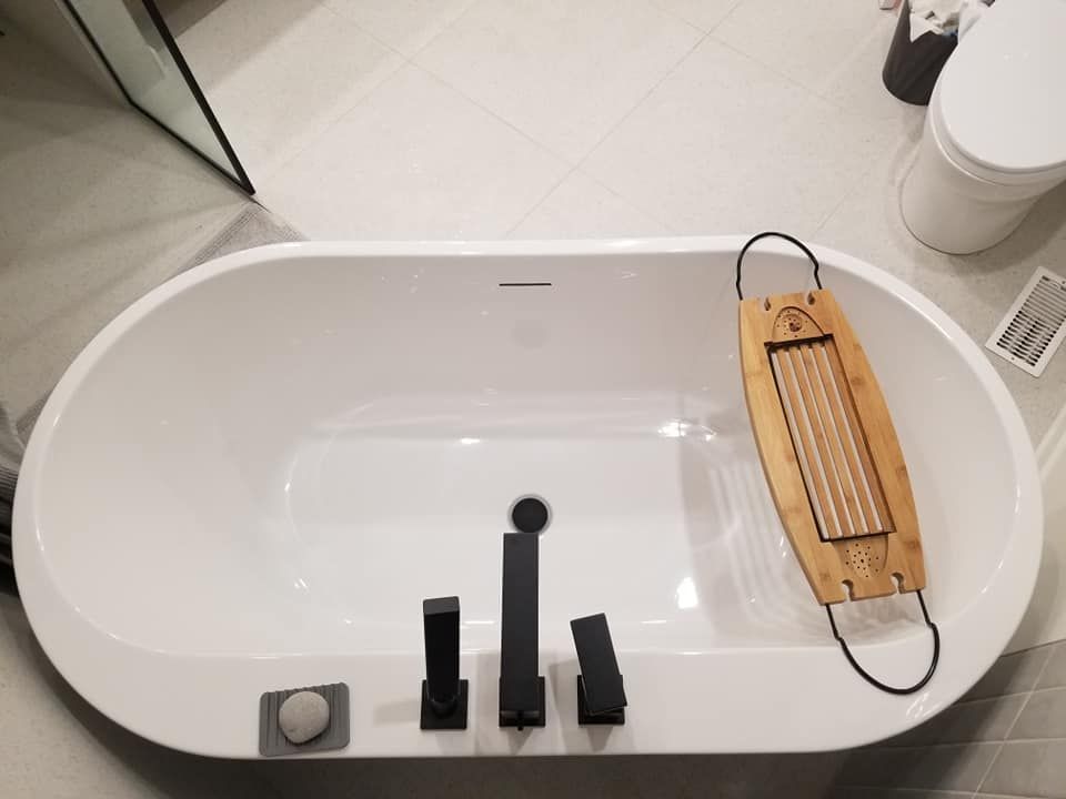 Une baignoire avec un plateau de baignoire en bois au-dessus