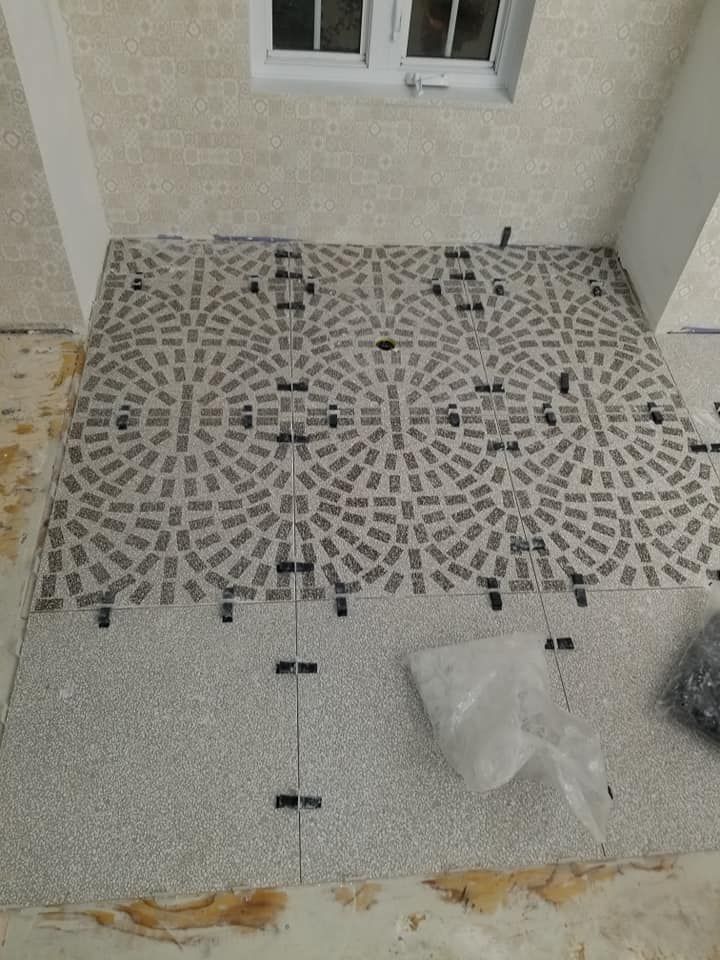 Un sol carrelé est en cours d'installation sur un porche.