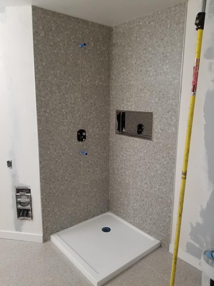 Une salle de bain avec douche à l'italienne et un mètre ruban.