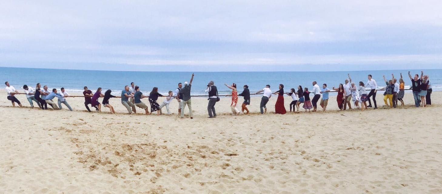 Wedding photography at Bournemouth of a tug of war between bride and groom.