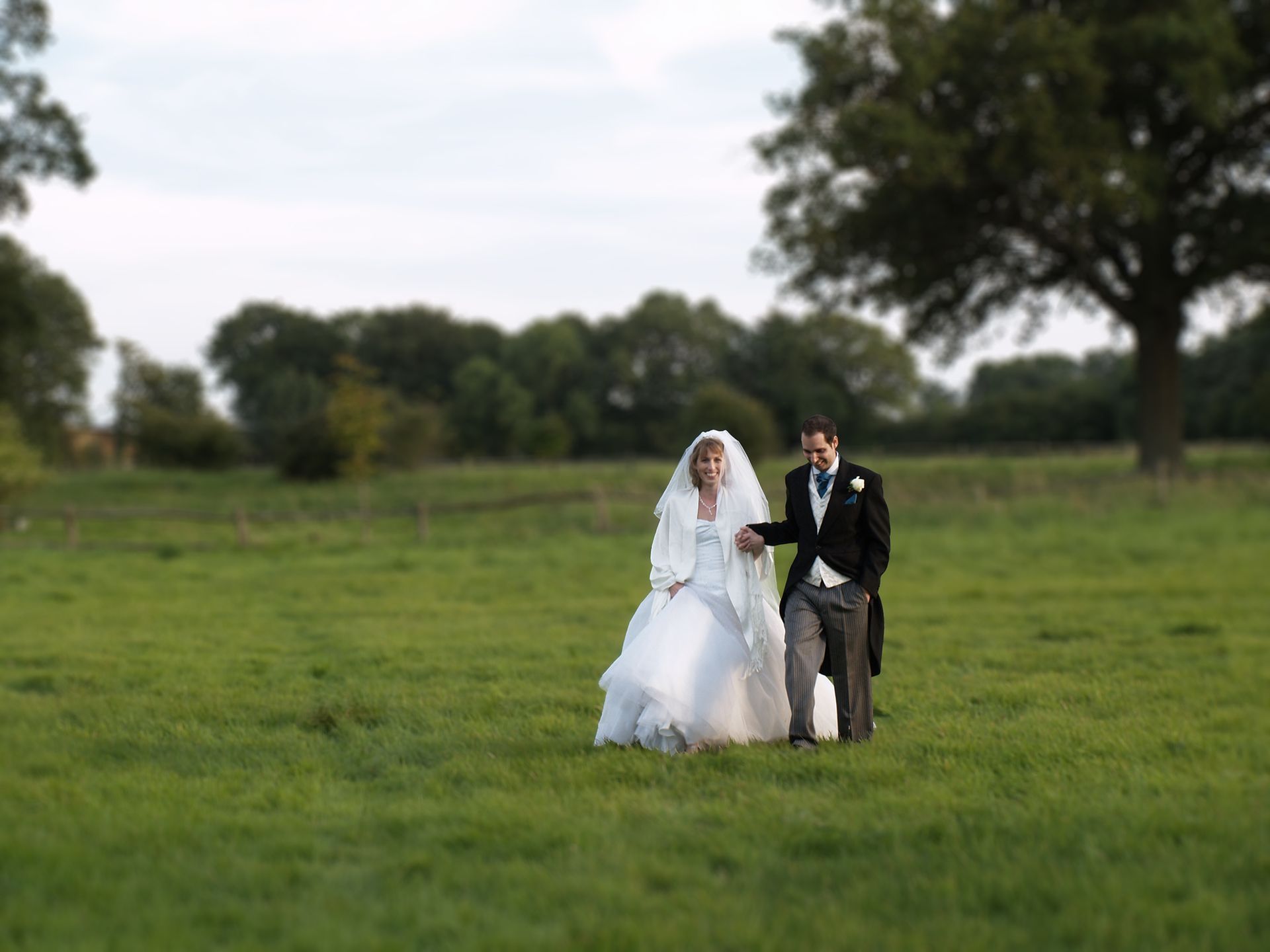 The bride and groom after the wedding, photographed walking across a field in Poole, Dorset.