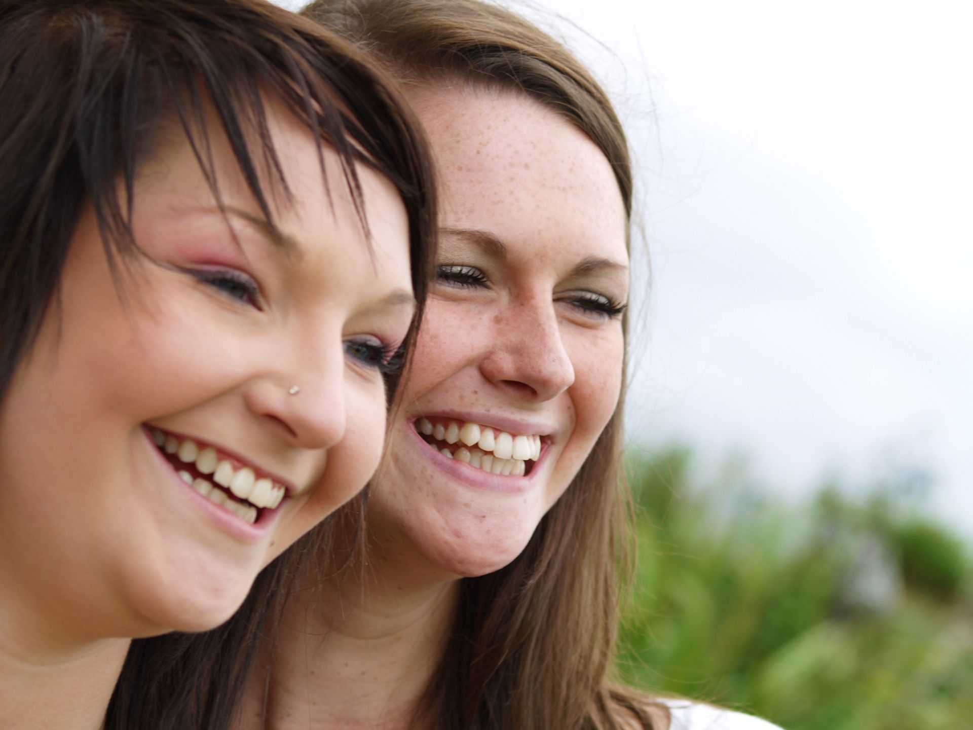 Two bridesmaids photographed smiling at wedding in Poole.