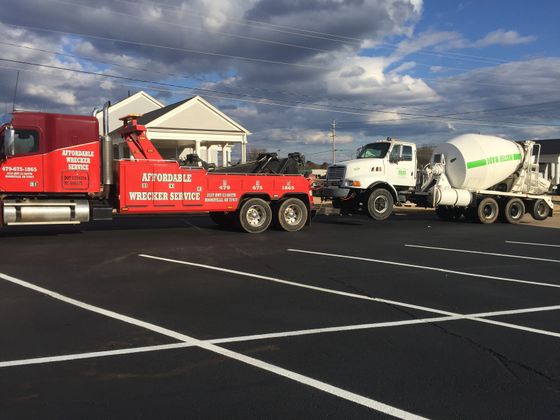 Towing a broken down car on road in Boonville, AR