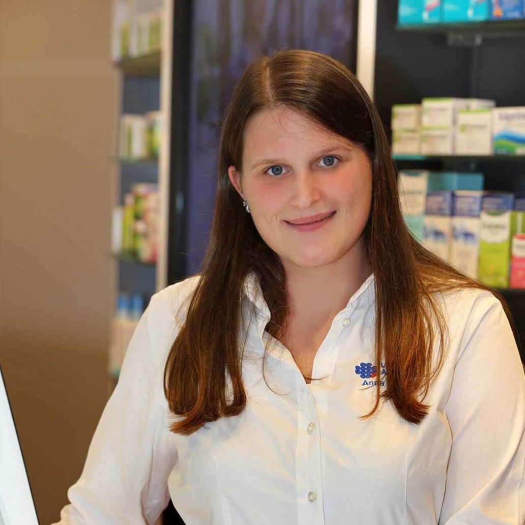 Eine Frau in einem weißen Hemd sitzt vor einem Computer