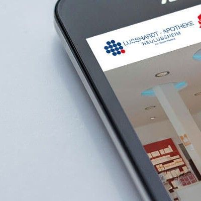 Eine Nahaufnahme eines Mobiltelefons, auf dem die Website der Lusshardt-Apotheke angezeigt wird