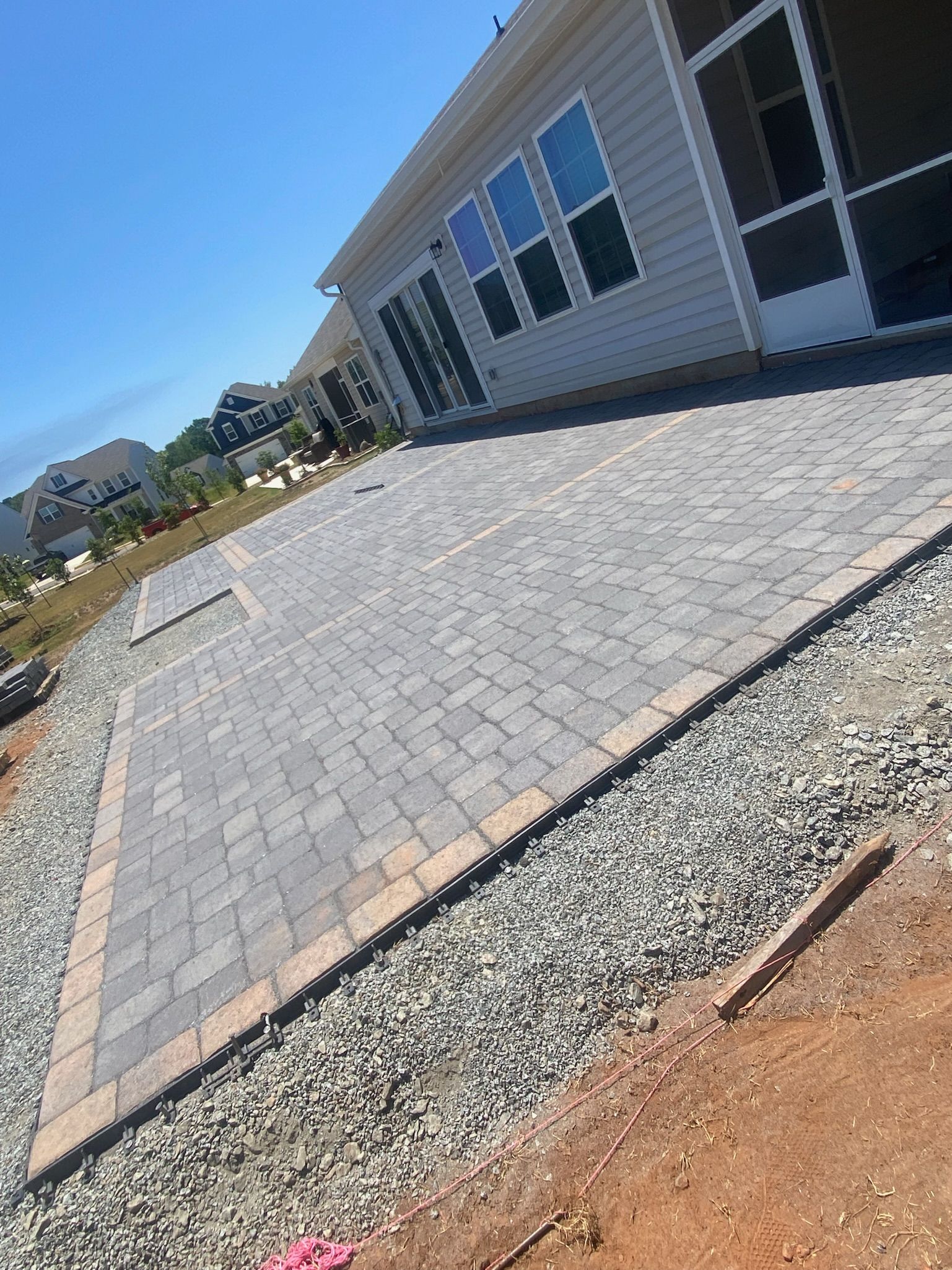 A house with a driveway and gravel in front of it.