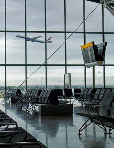 A plane is flying over an airport waiting area