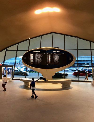 People walking in front of a large sign that says departures