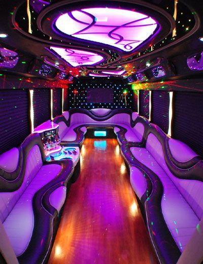 The inside of a limousine with purple lights on the ceiling