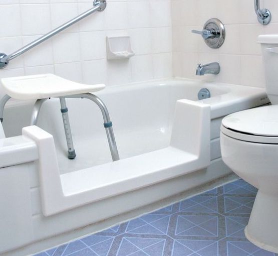 A bathroom with a toilet a bathtub and a stool