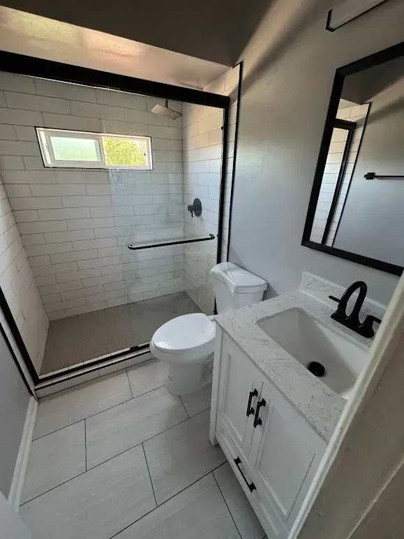 A bathroom with a toilet , sink , and shower.
