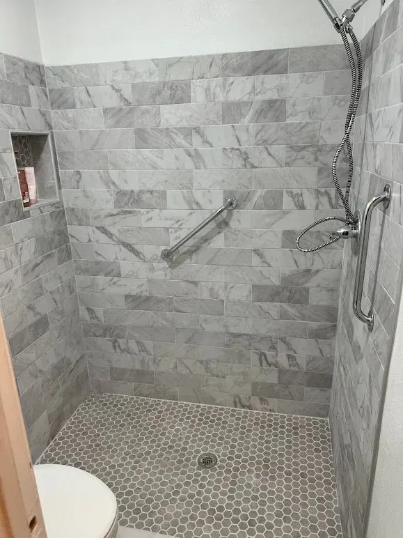 A bathroom with a walk in shower and a toilet.