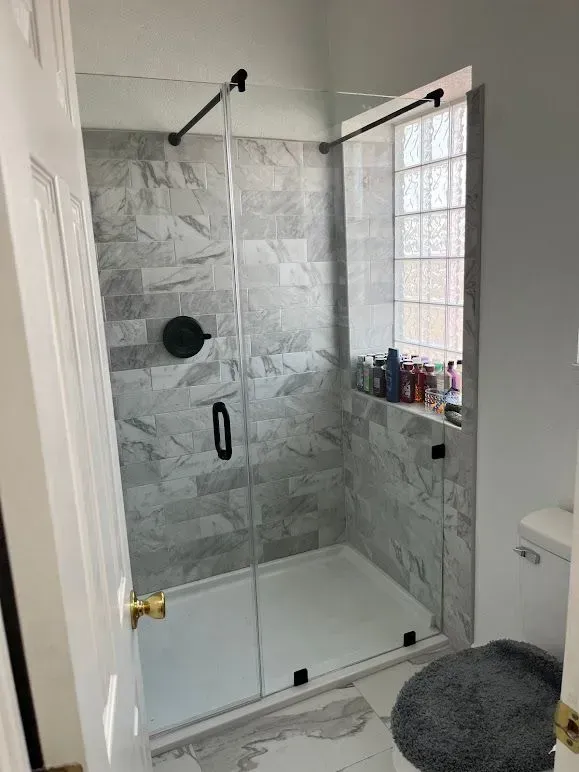 A bathroom with a walk in shower and a toilet.