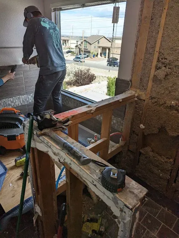 A man is working on a wall in a room.