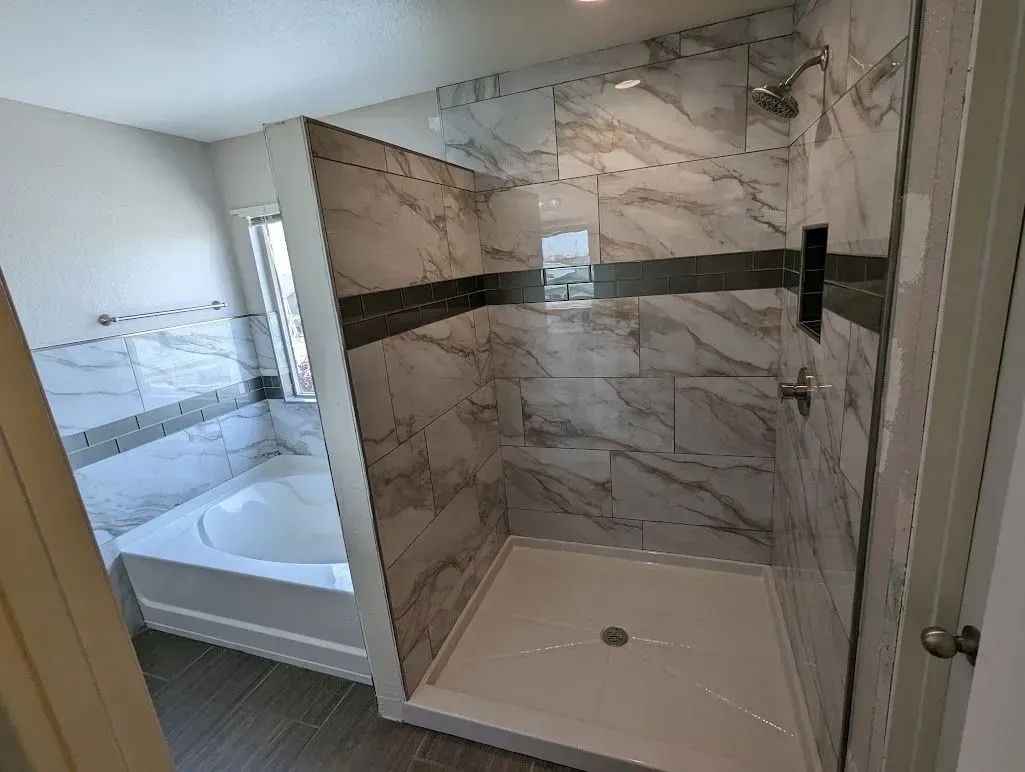 A bathroom with a tub and a walk in shower.