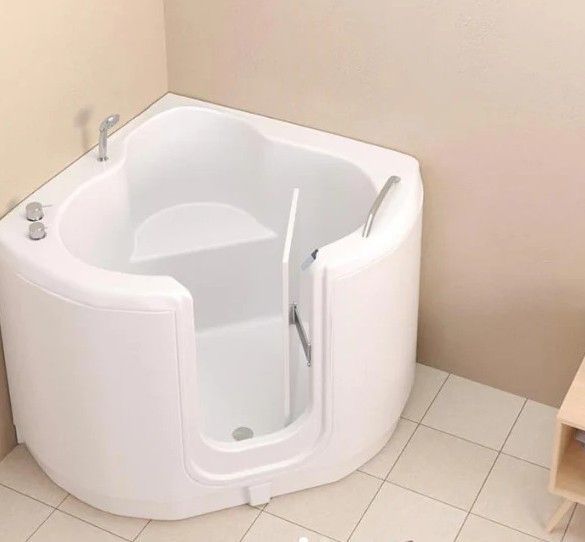 A white bathtub with a door in a bathroom.