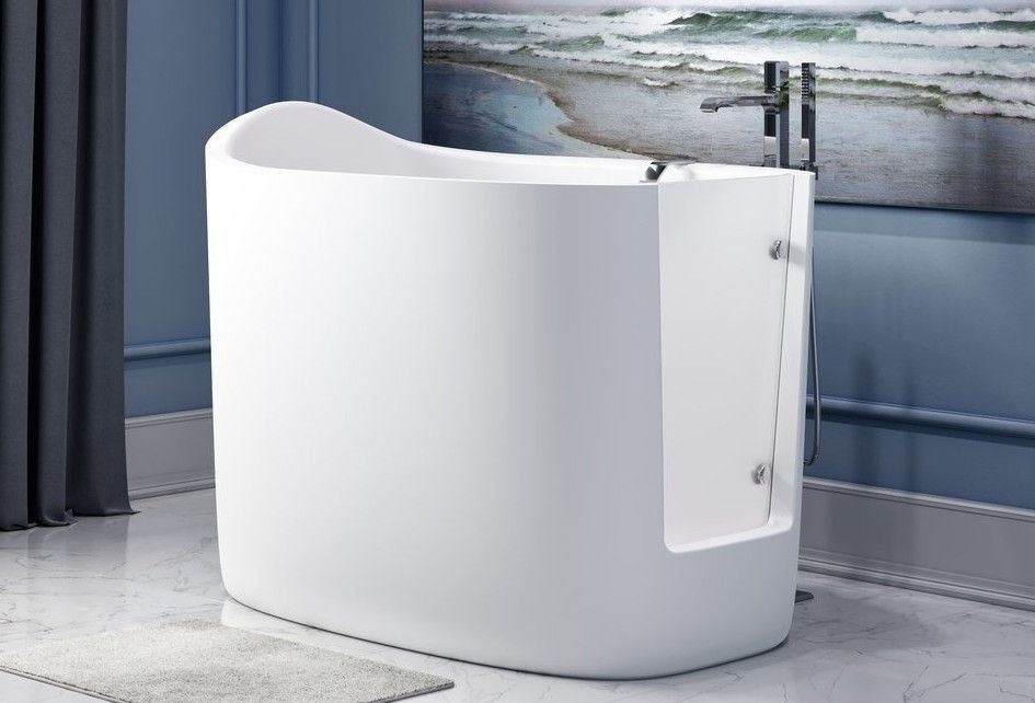 A white bathtub in a bathroom with a picture of the ocean on the wall behind it.