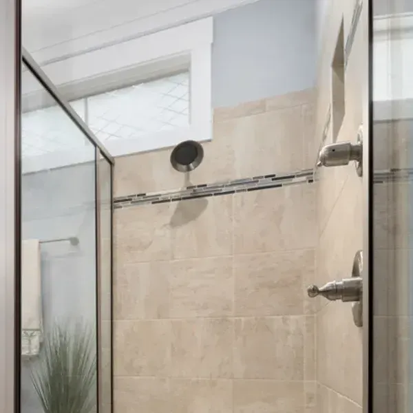 A bathroom with a walk in shower and a window