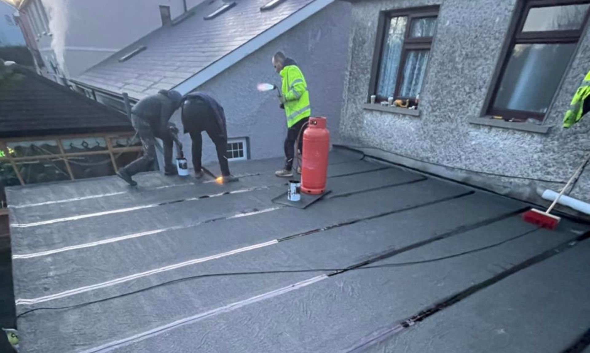 A group of people are working on the roof of a building.