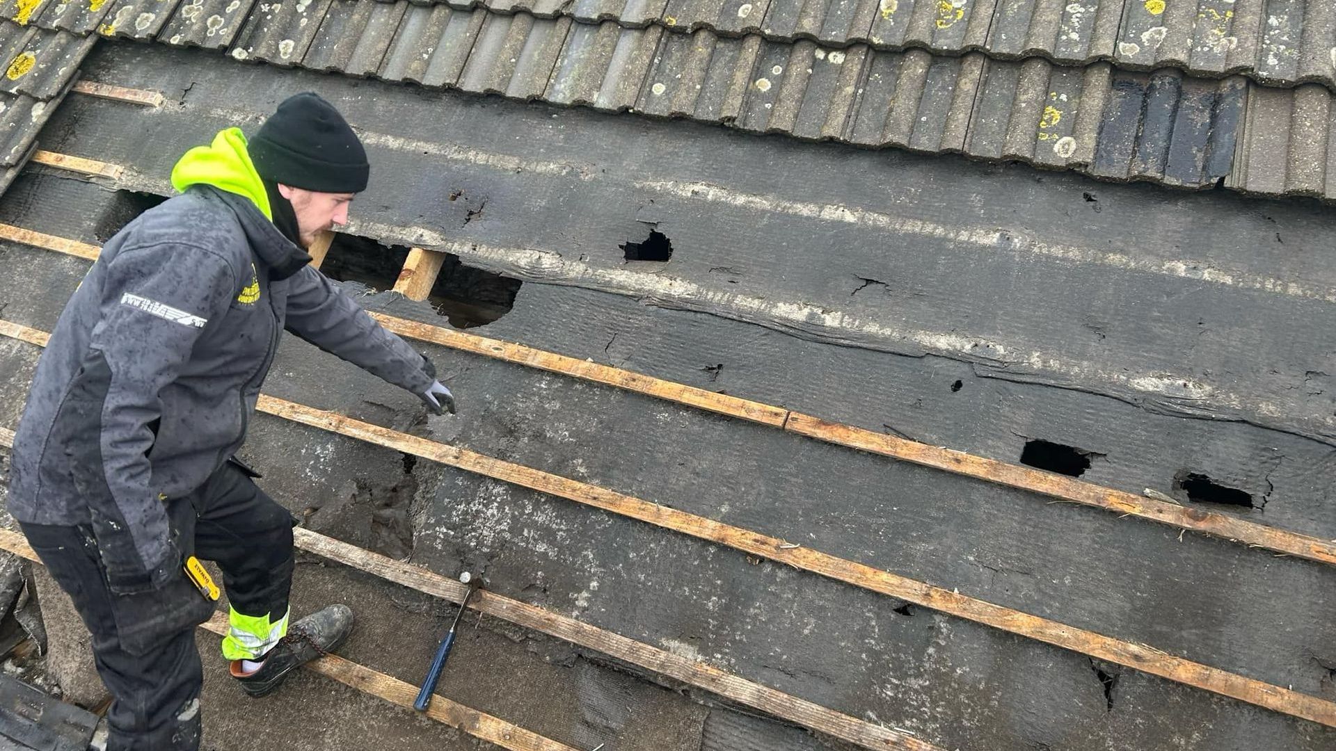 A man is working on the roof of a building.