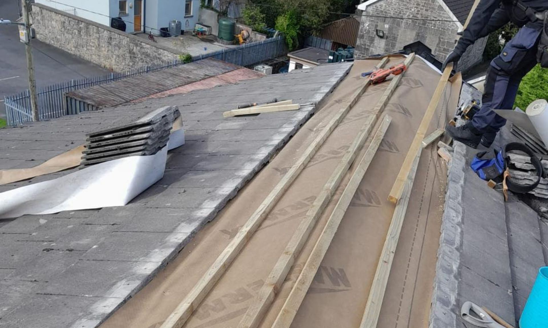 A man is working on the roof of a house.