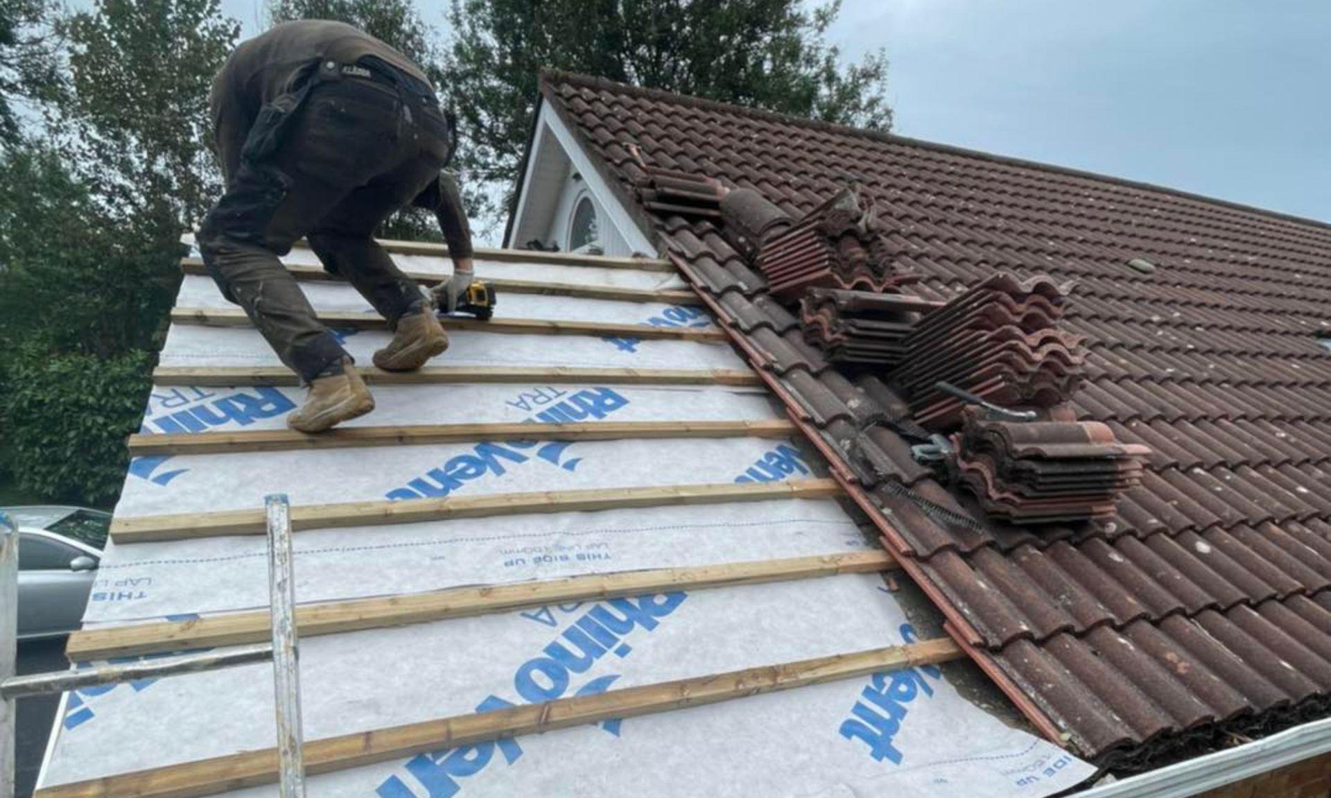 A man is working on the roof of a house.