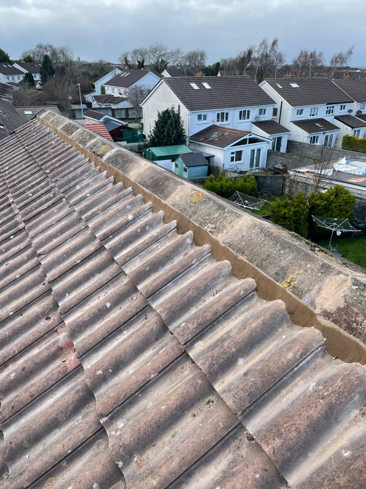 An aerial view of a roof with a row of houses in the background.