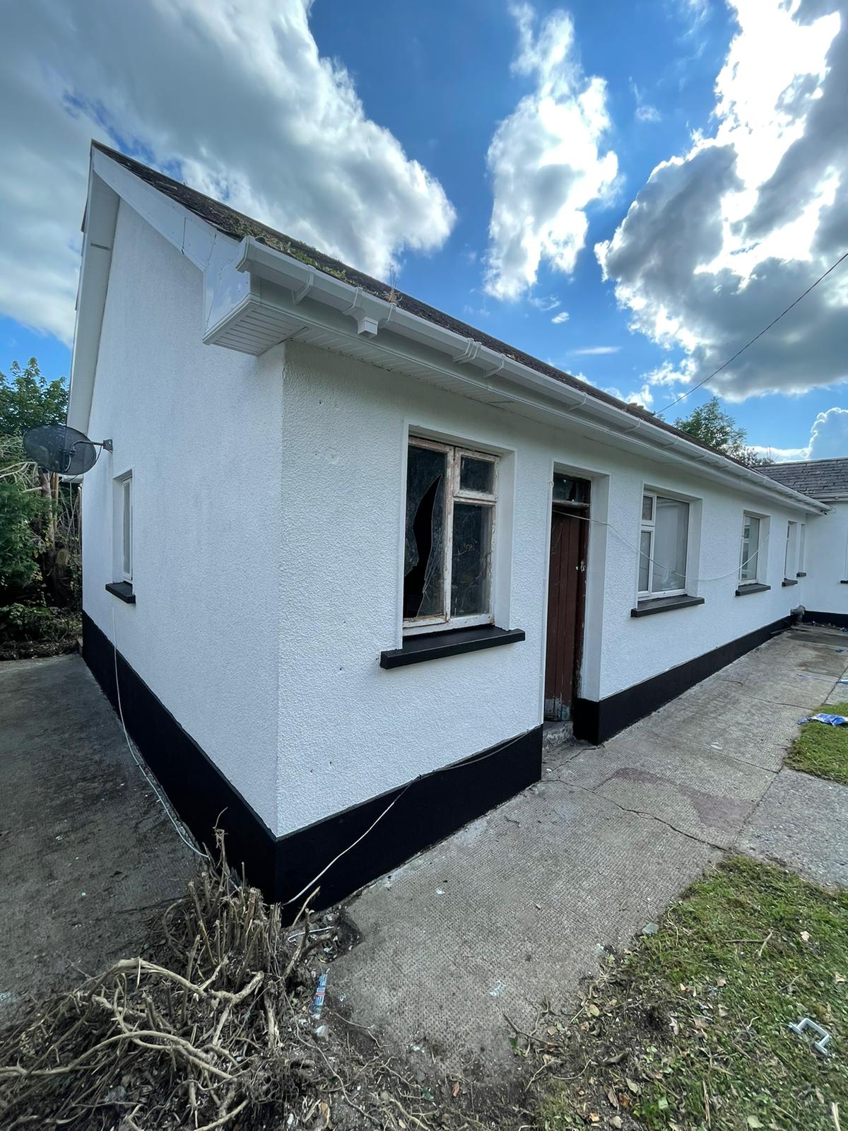 A white house with black trim and a blue sky in the background.