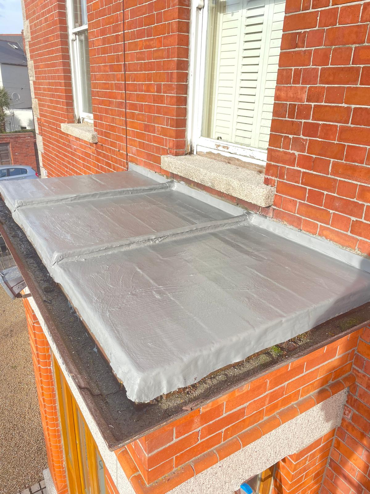 A brick building with a roof that is covered in a tarp.