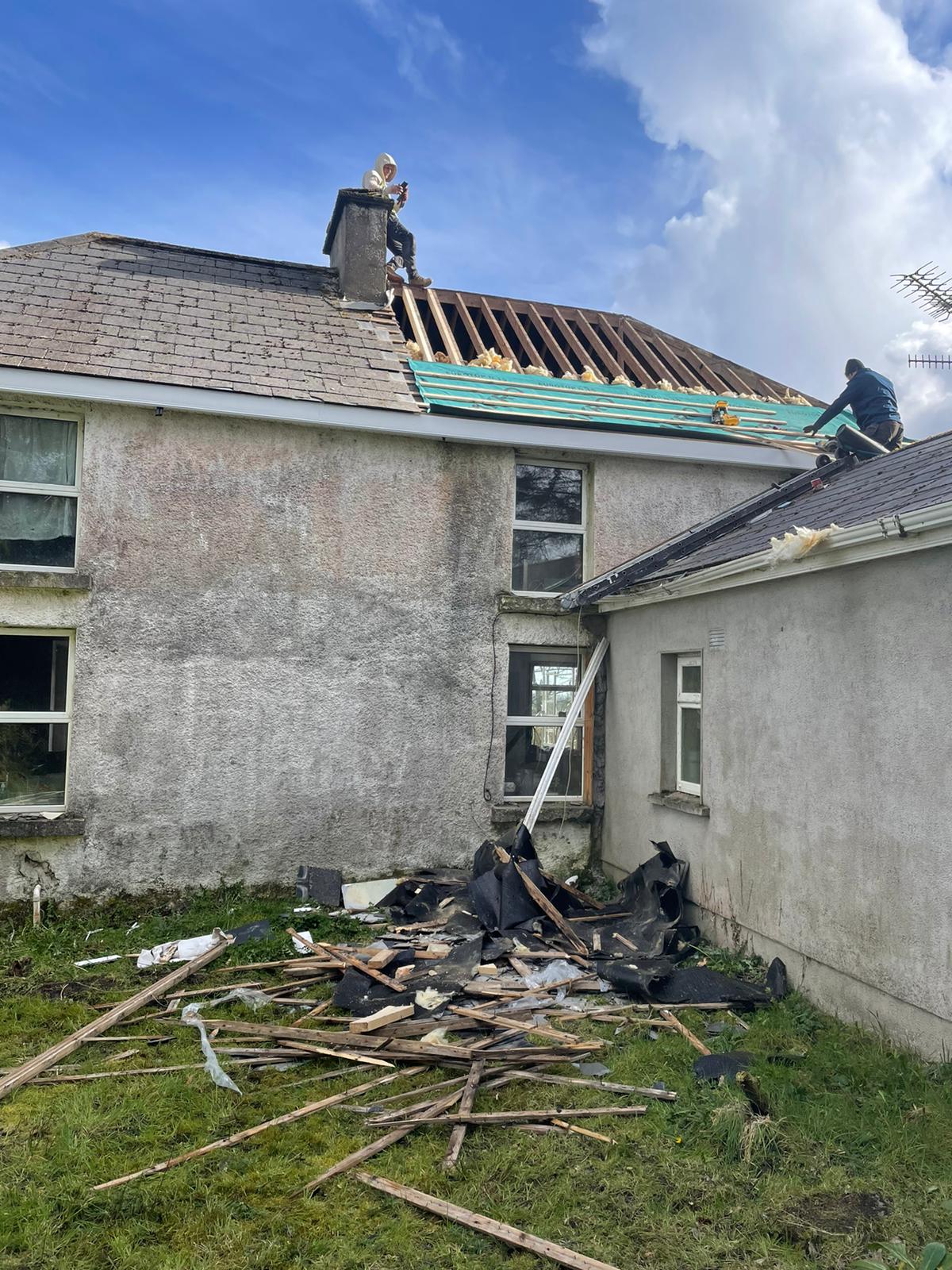 A man is working on the roof of a house.