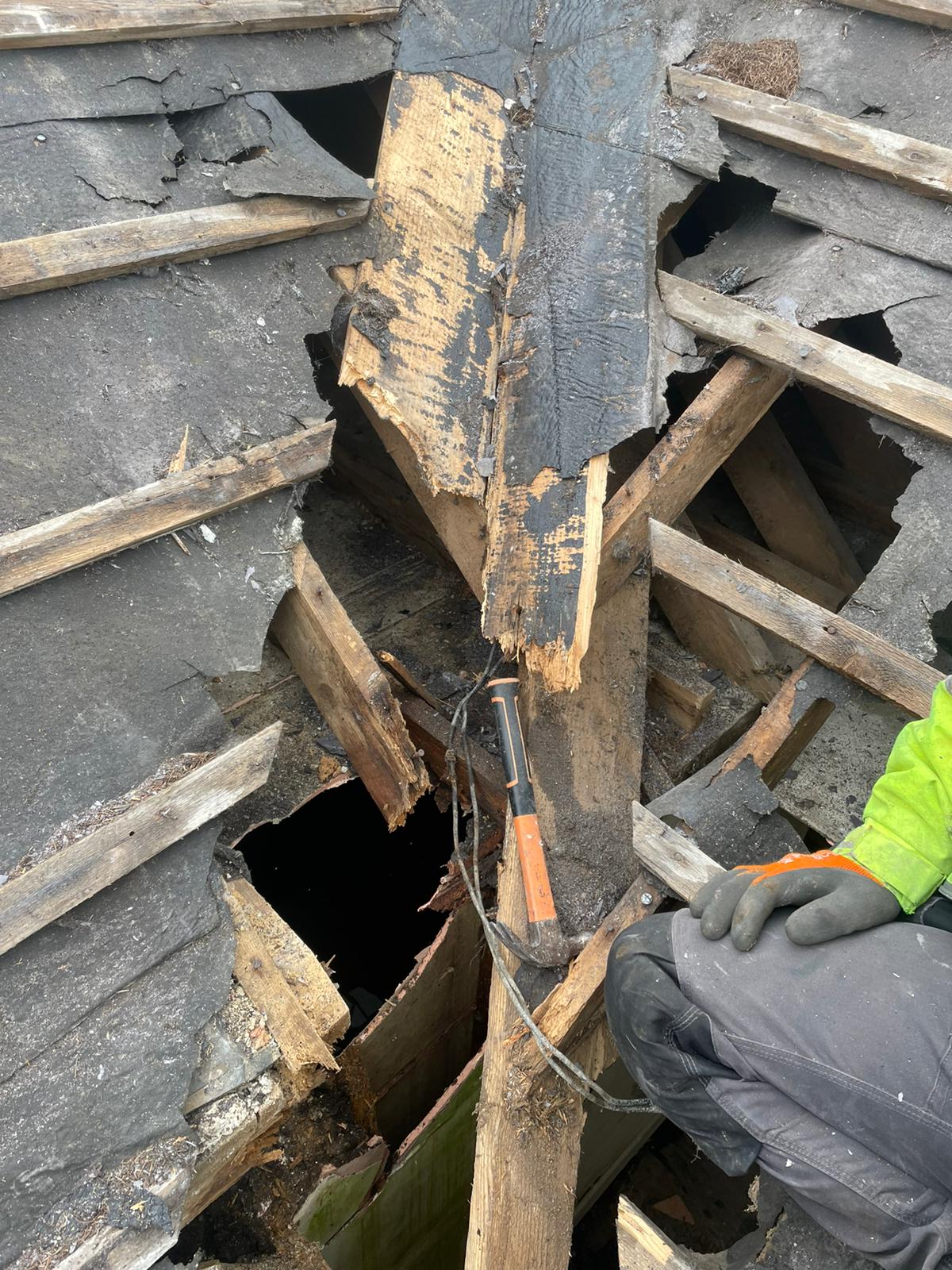 A person is cutting a piece of wood with a pair of scissors.