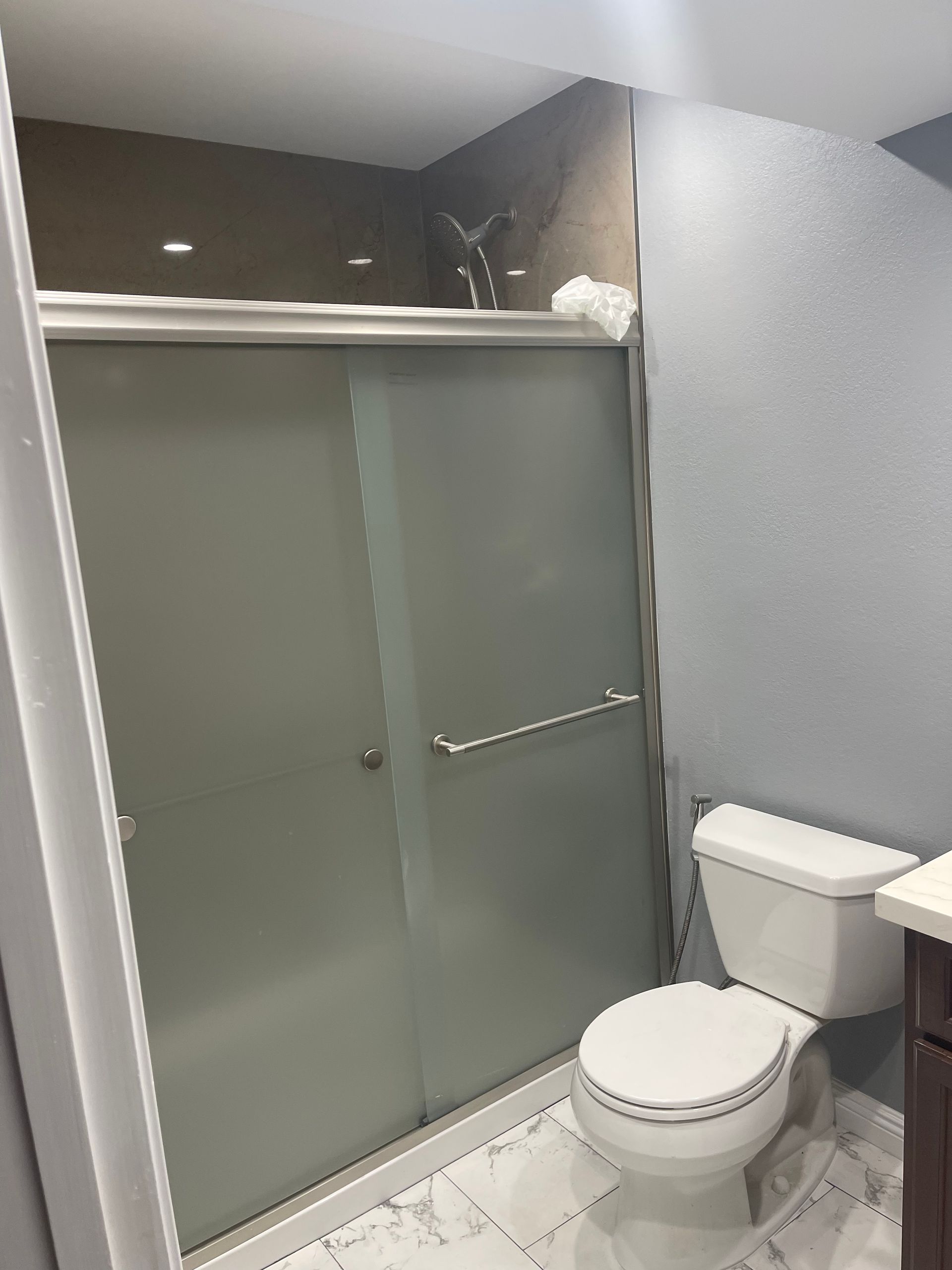 Bathroom with a toilet and a sliding glass shower door — San Jose, CA — DB Remodeling