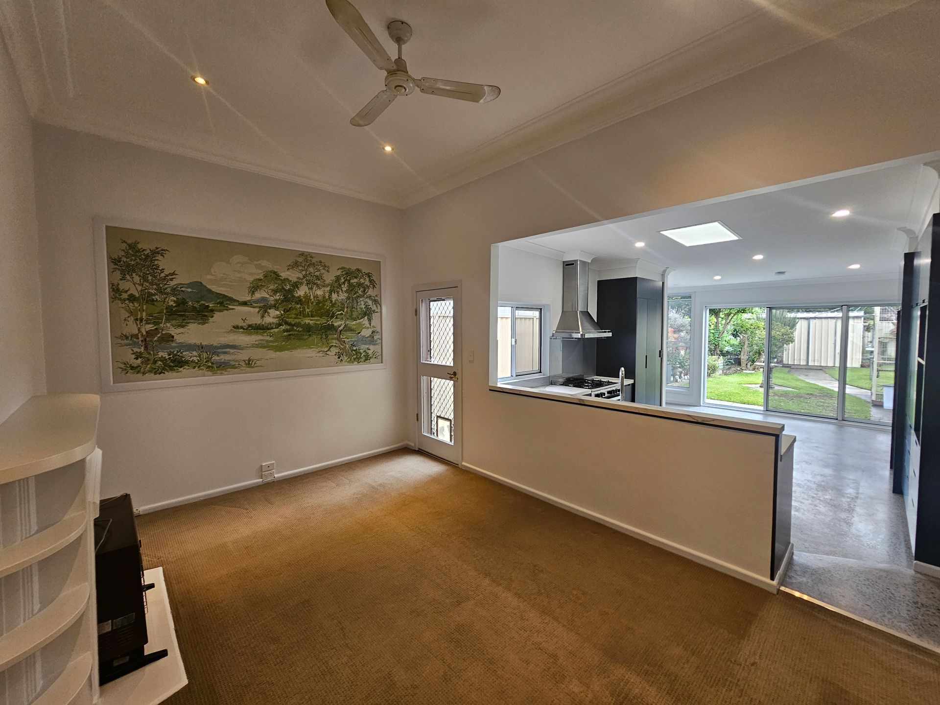 Renovated open-plan living and kitchen area with modern dark cabinetry Renovated open-plan living and kitchen area with modern dark cabinetry