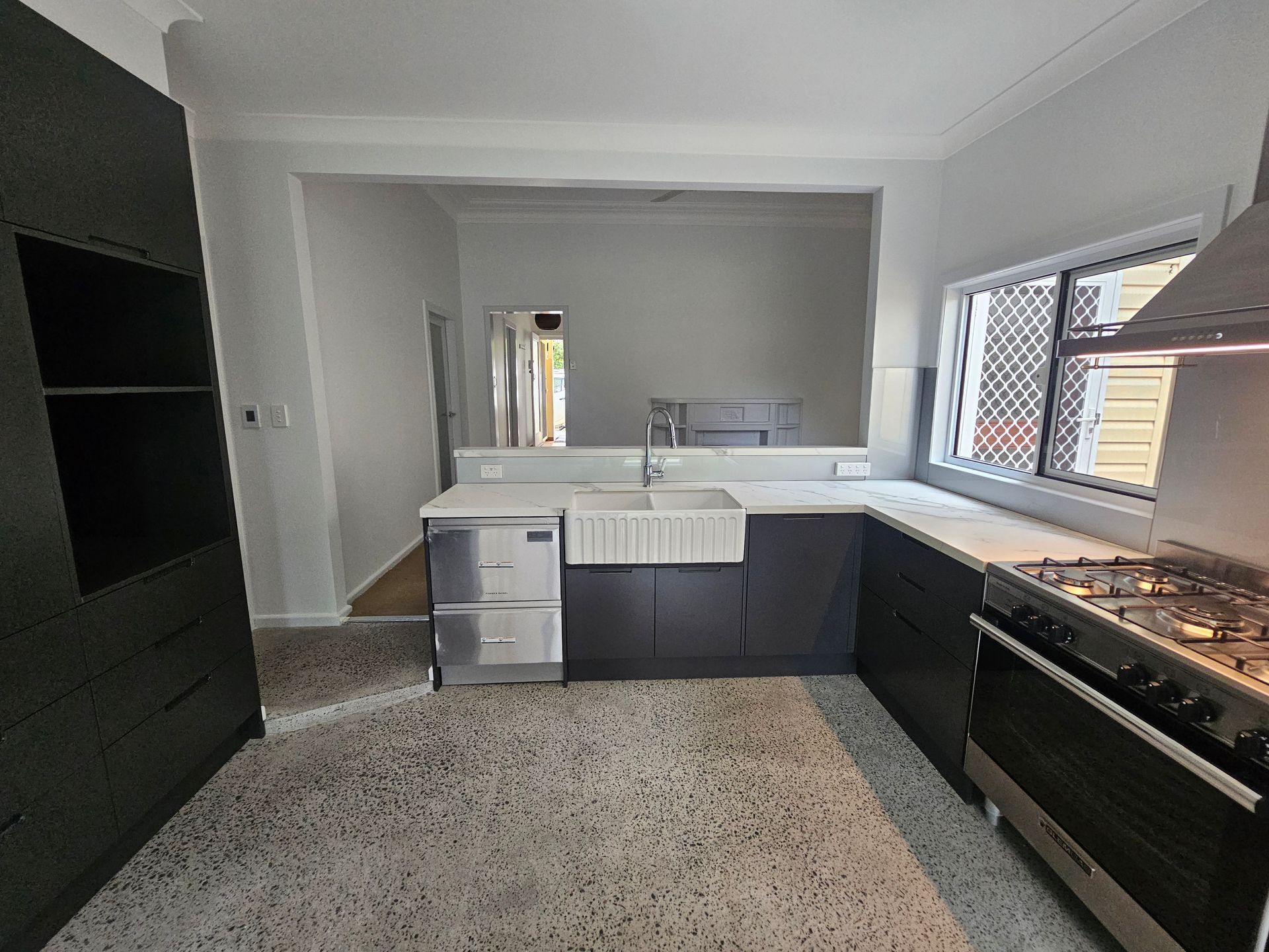Renovated open-plan kitchen area with modern dark cabinetry. Renovated open-plan kitchen area with modern dark cabinetry.