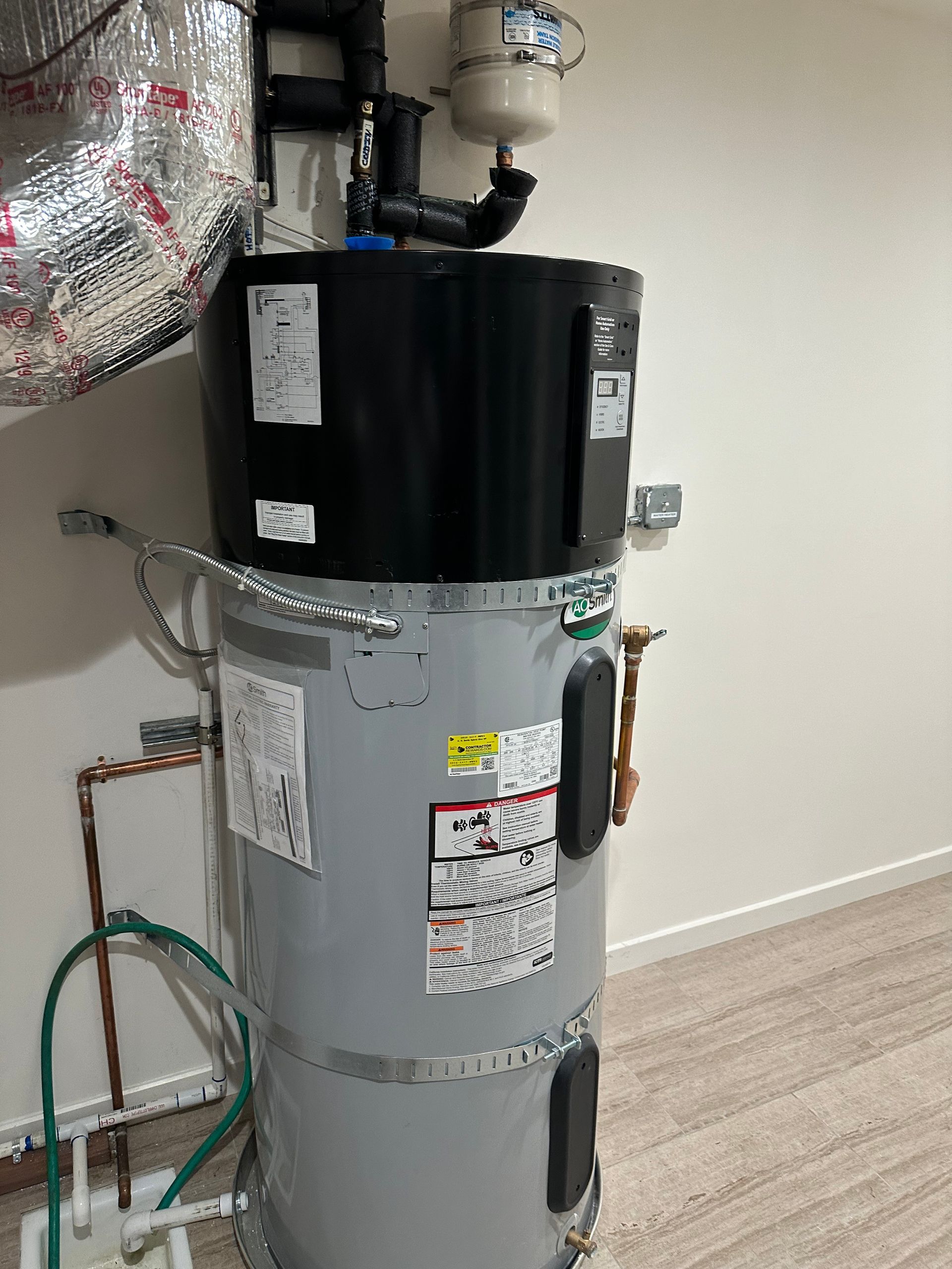 Adult helping two children in a bright bathroom, one in a bathtub and one standing beside it.
