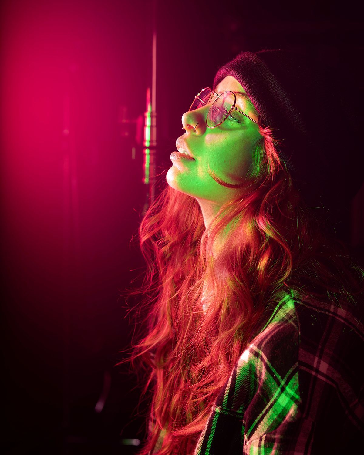 female with hat and glasses in red and green glow
