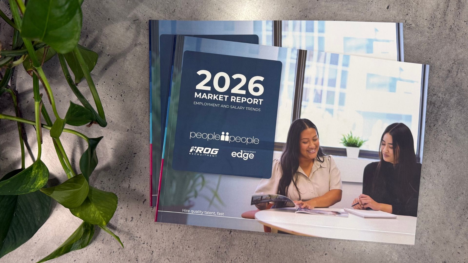 A report brochure open on a table, featuring charts, data, and photos.