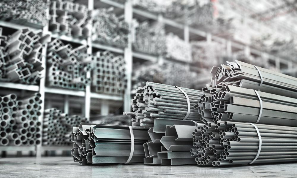 A Bunch of Metal Pipes Are Stacked on Top of Each Other in A Warehouse — FBM Fabrication In Dapto, NSW