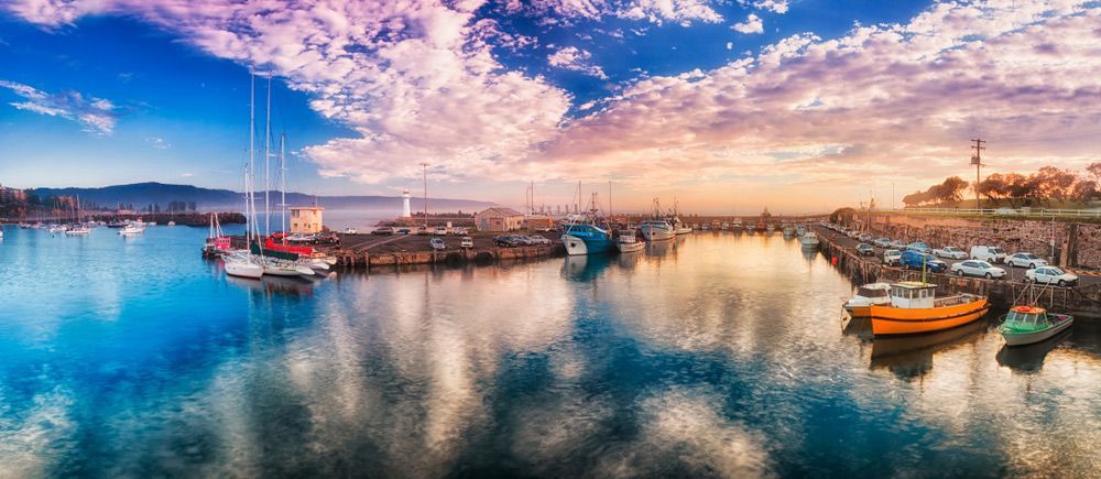A Group of Boats Are Docked in A Harbor at Sunset — FBM Fabrication In Wollongong, NSW
