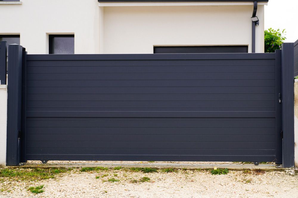 A Black Sliding Gate Is in Front of A White House — FBM Fabrication In Nowra, NSW