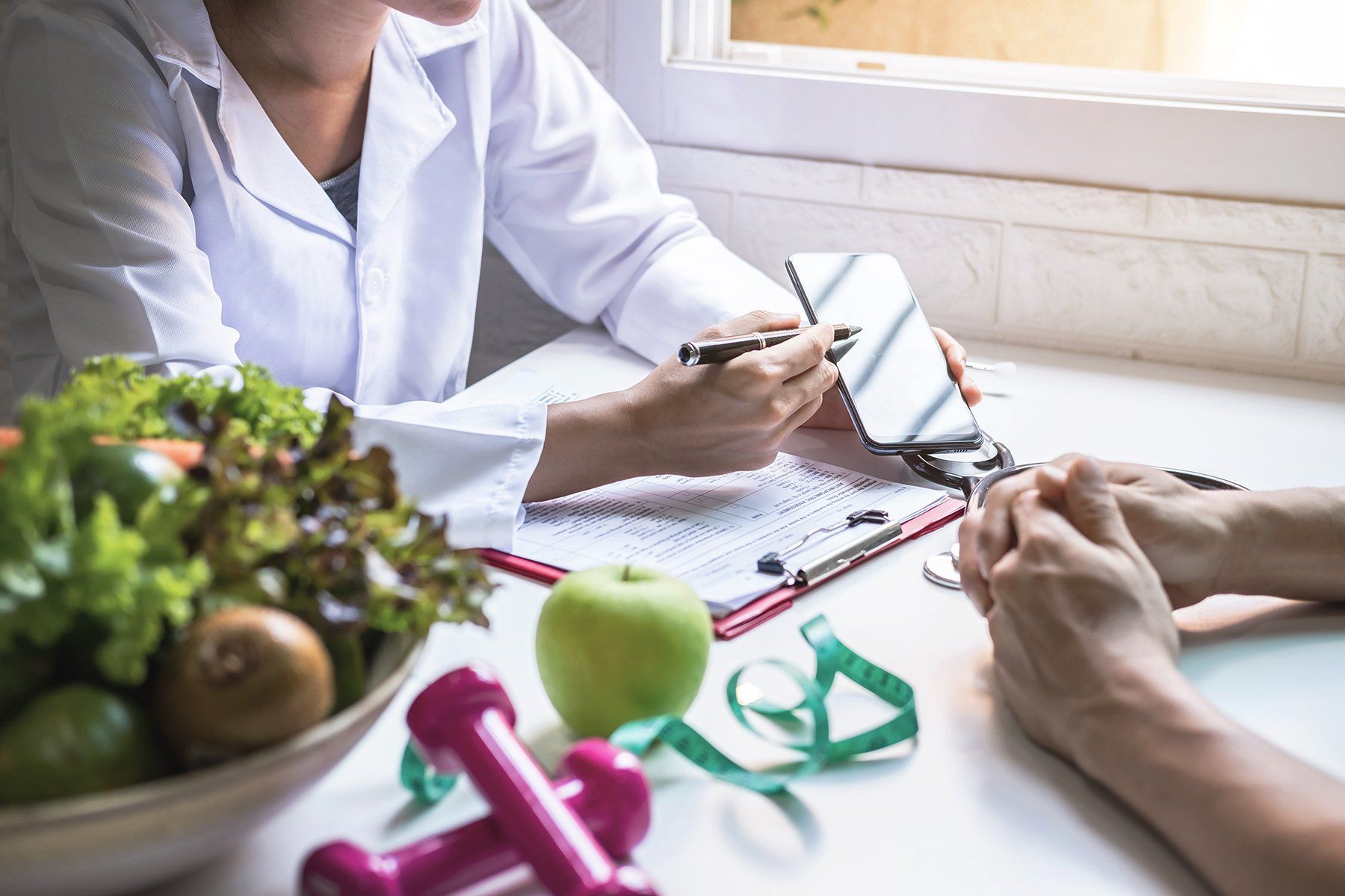 Nutritionist consulting patient with phone