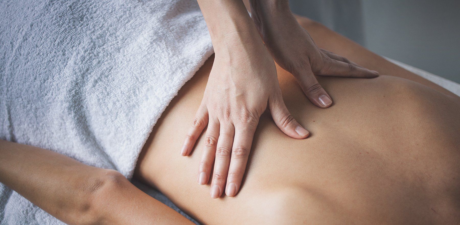 Massage therapist pressing lower back