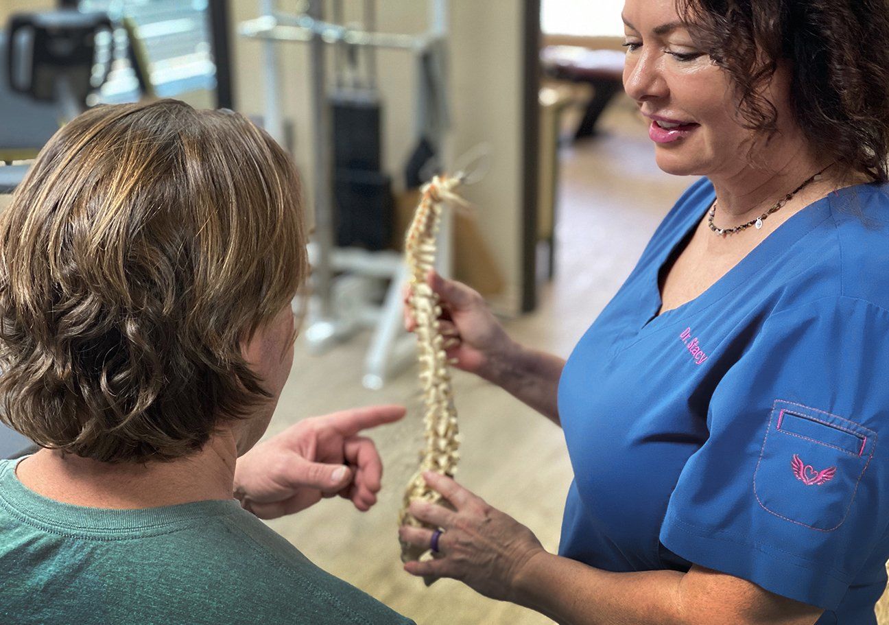 Chiropractor explaining spine model to patient