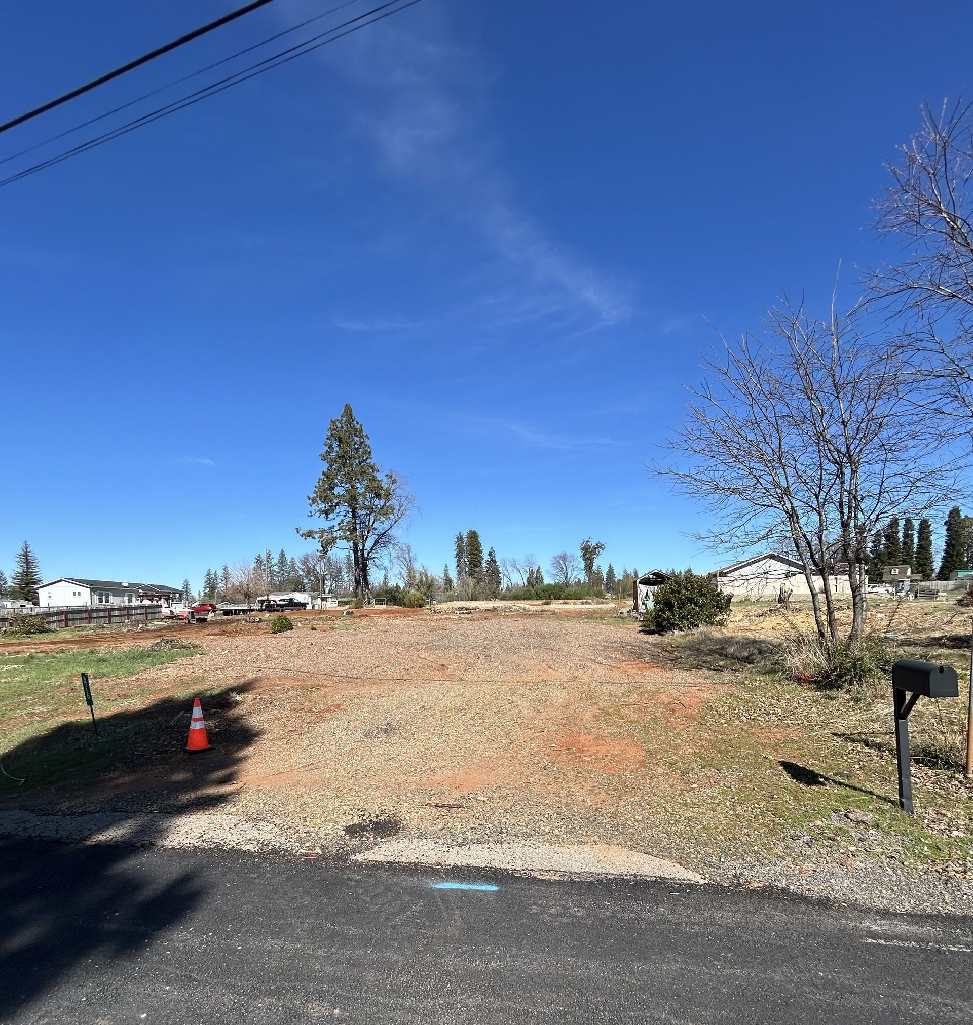 Cleared lot, ready for construction, under a clear blue sky.