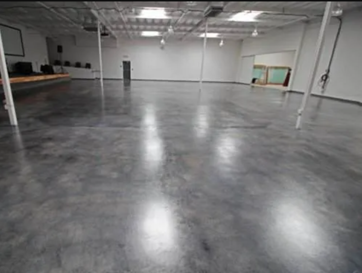 Empty, spacious room with polished concrete floor, white walls and ceiling.